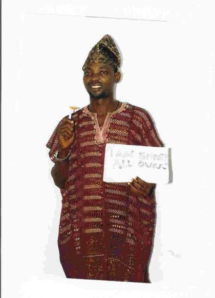 Malike Bamiyi holding a sign that says 'I'm smooth all over' in one hand and a disposable razor in the other.